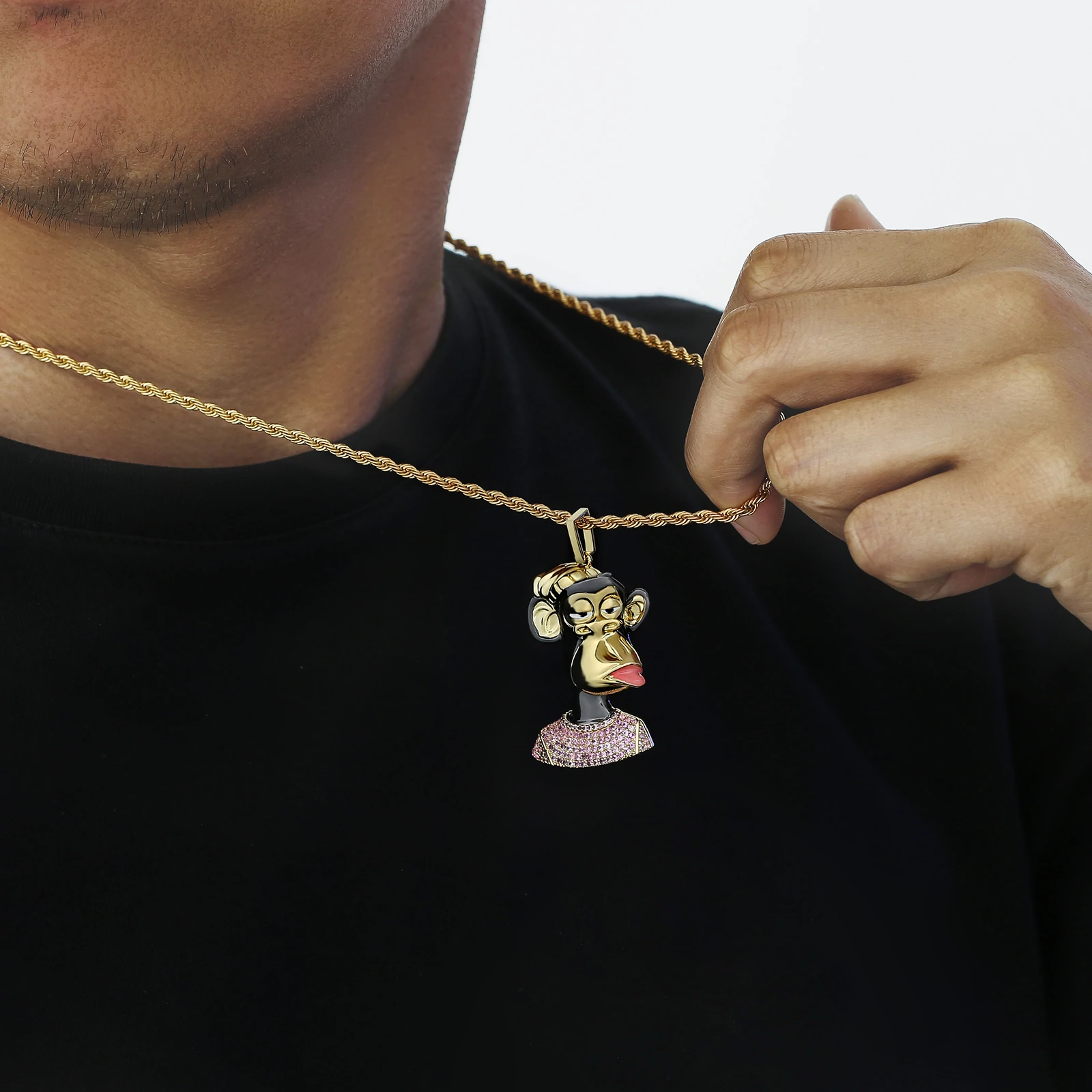 Gold Bored Ape pendant held in hand, showing crystal details on base