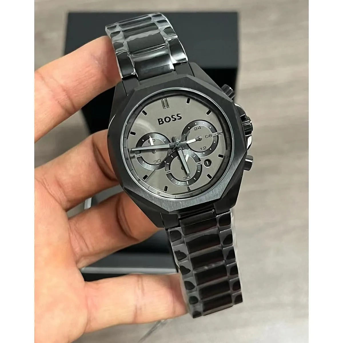 BOSS black steel chronograph watch in hand showing dial detail and metal bracelet