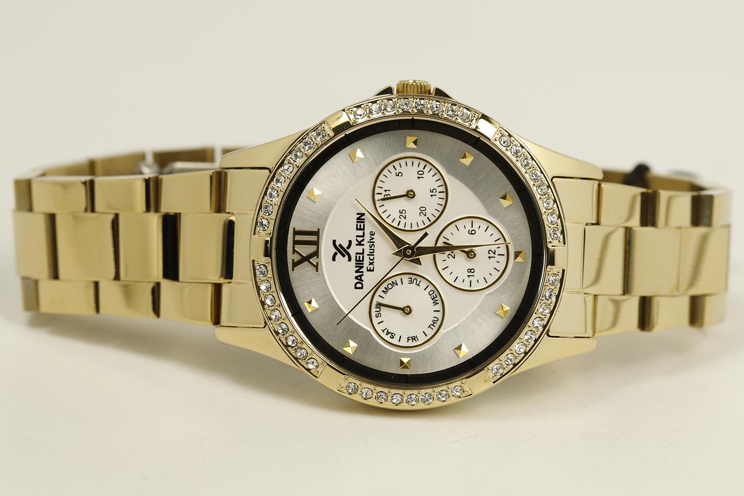 Side angle view of gold multifunction watch with link bracelet and dial detail