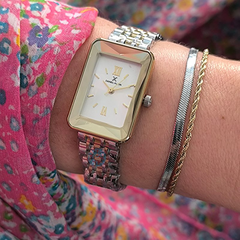 Daniel Klein rectangular two-tone watch worn on wrist with colorful sleeve