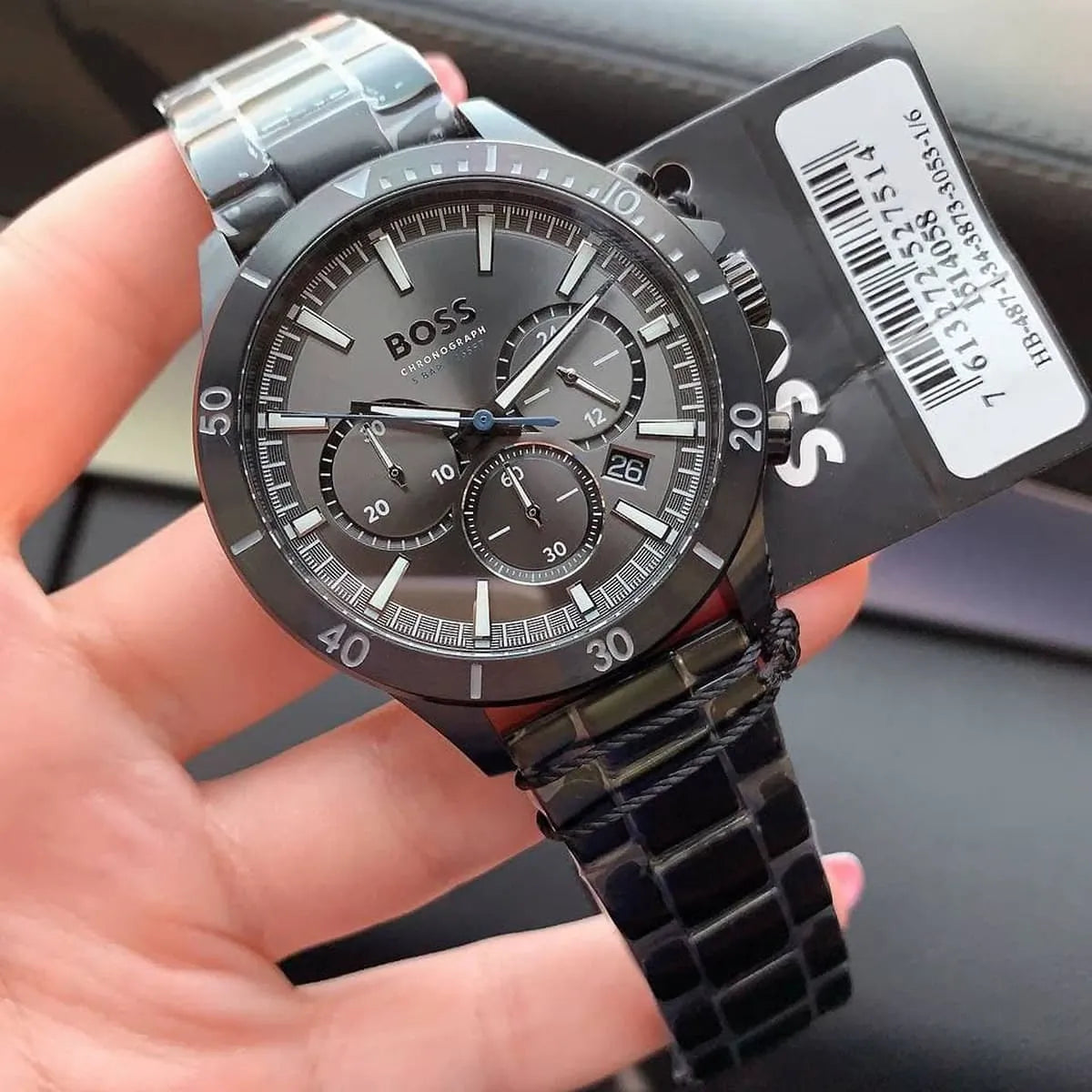 Hugo Boss Troper chronograph watch held in hand showing black dial and black metal bracelet