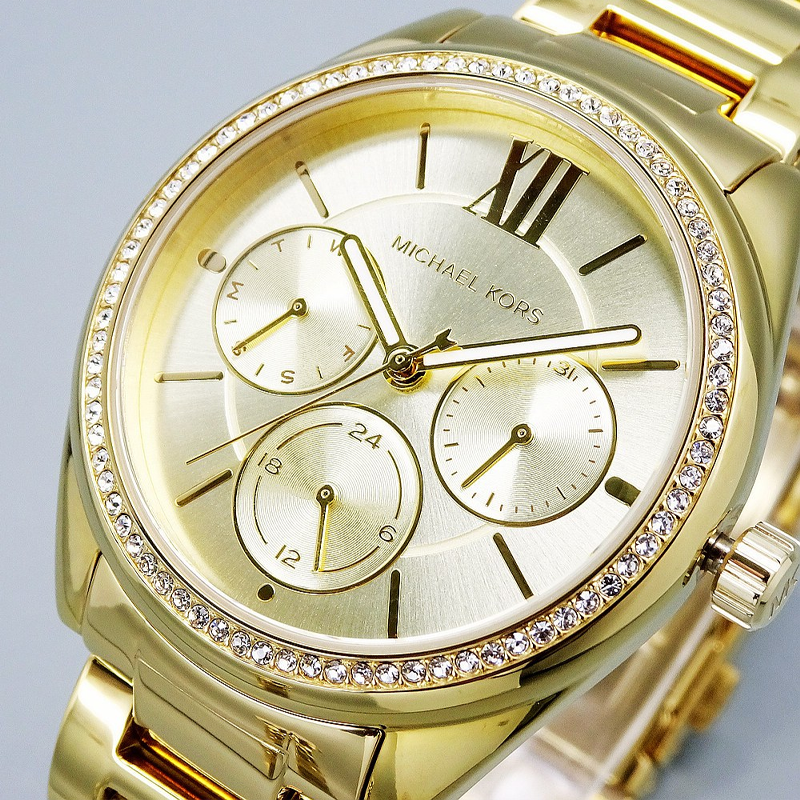 Close-up of Michael Kors MK7090 dial showing Roman numerals, three subdials, and gold-tone hands