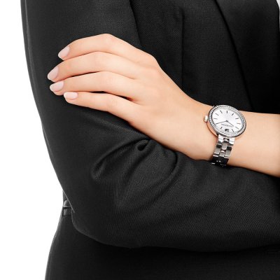 Swarovski Octea Sport watch worn on woman's wrist with white dial and steel bracelet