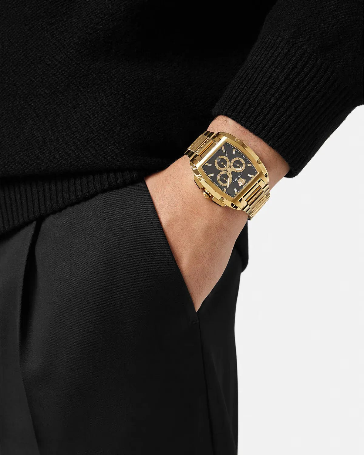 Versace Dominus watch on wrist styled with black sweater and trousers, showing gold case detail
