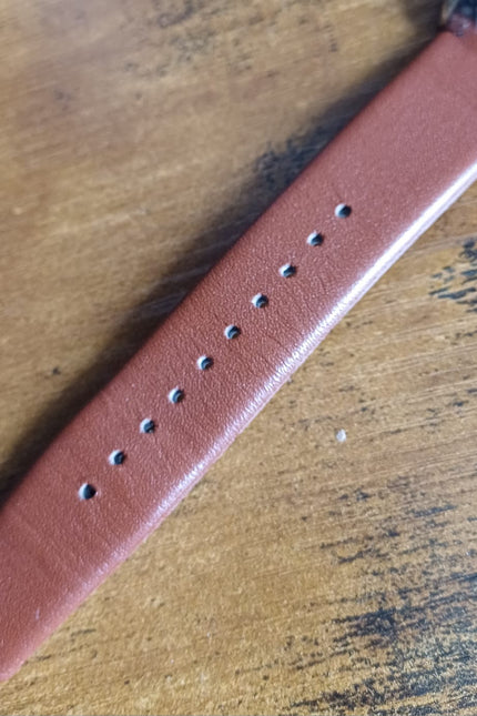 Brown leather strap with adjustment holes and buckle attachment point