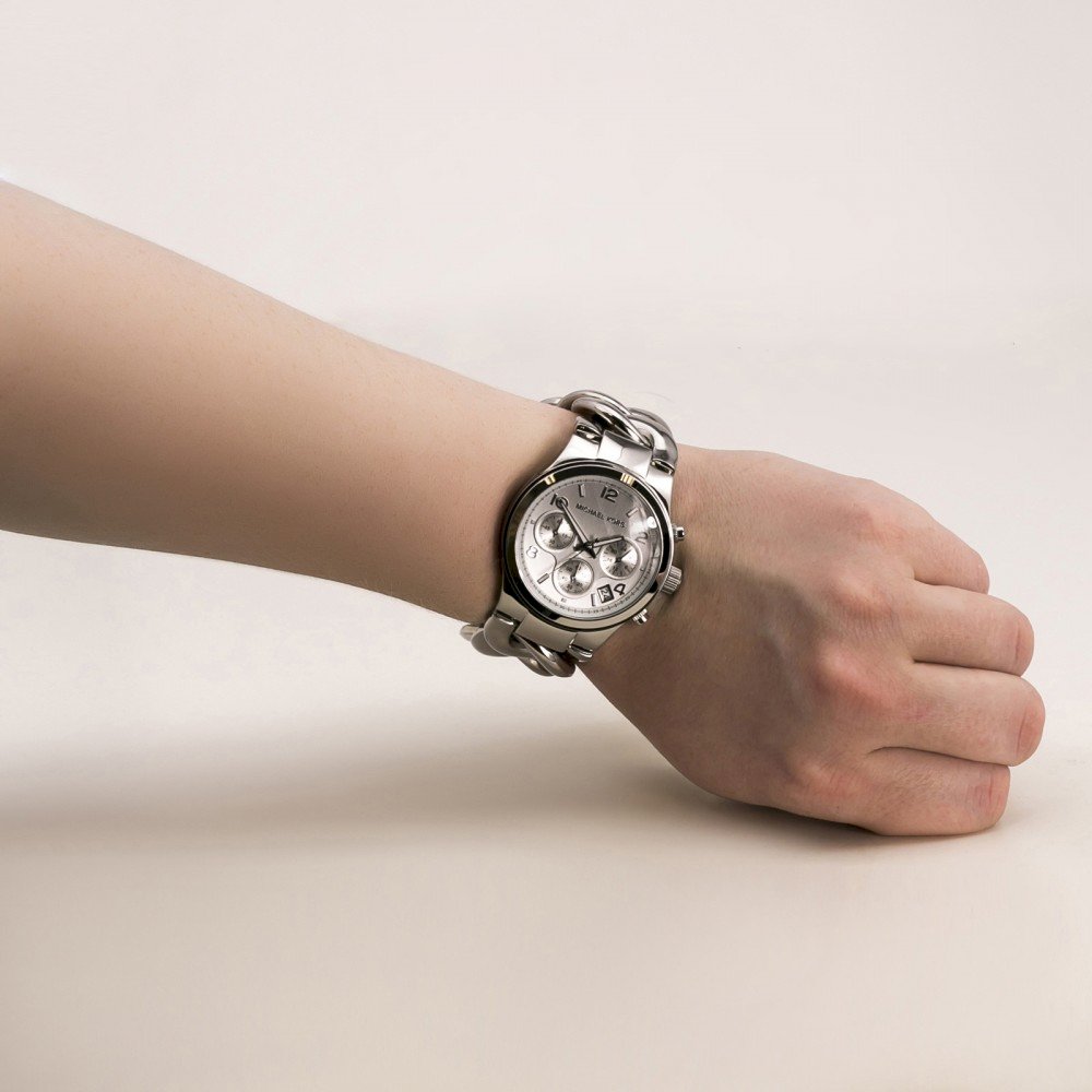 Michael Kors Runway Twist MK3149 worn on wrist showing silver chronograph watch with white dial