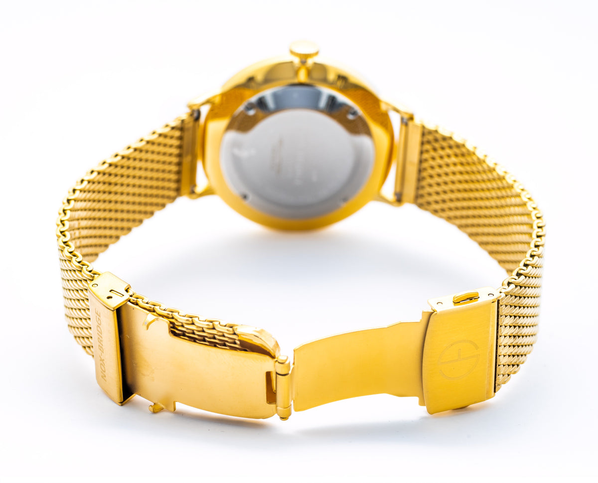 Noxbridge Vela watch on wrist with gold mesh bracelet and white dial