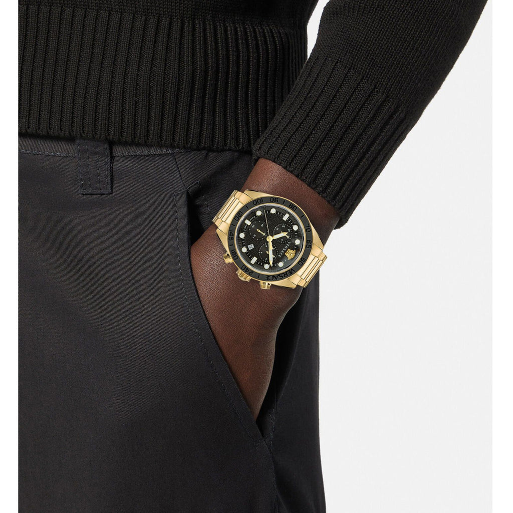 Versace Greca Dome chronograph watch worn on wrist with gold case and black dial
